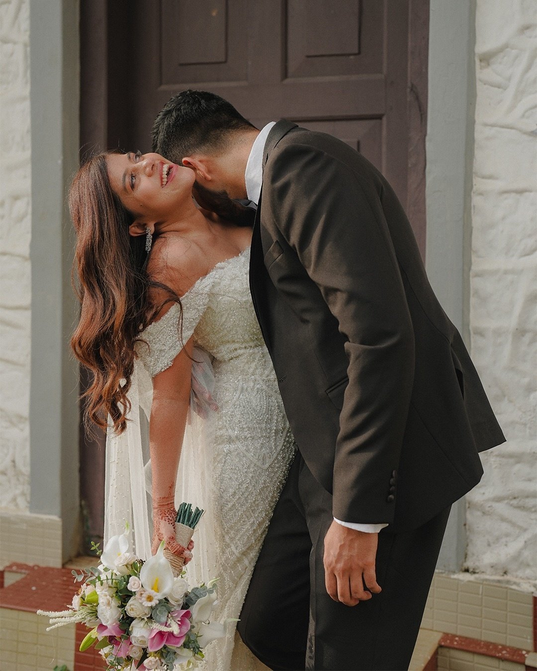 Newlyweds standing close in traditional wedding attire